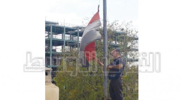 یکی از کارکنان سفارت یمن در تهران به هنگام پایین کشیدن پرچم یمن – عکس از الشرق الأوسط