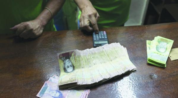 یک شهروند ونزوئلایی در حال شمارش اسکناس های پول در کاراکاس پایتخت ونزوئلا – عکس از رویترز