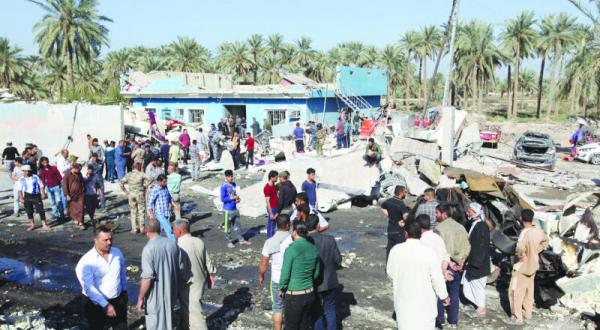 عراقی ها در محل انفجاری که یک ایست بازرسی در شهر الحله را هدف قرار داد – عکس از رویترز
