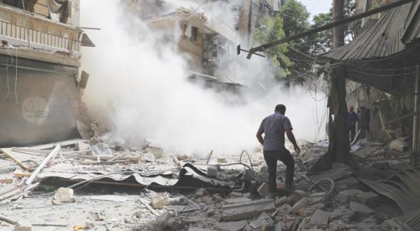 مردی در حال عبور بر ویرانه های ساختمان ها پس از بمباران محله القاطرجی در شرق حلب توسط نیروهای نظامی – عکس از خبرگزاری عربستان سعودی
