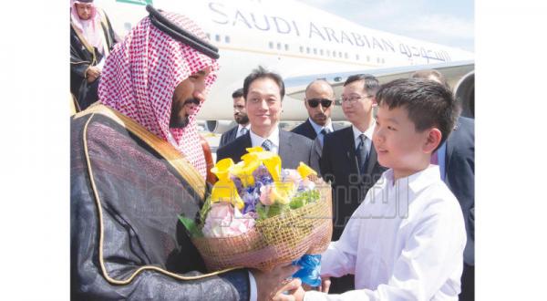 جانشین ولیعهد عربستان سعودی به هنگام ورود به پکن از یک کودک چینی یک دسته گل می گیرد – عکس از بندر الجلعود